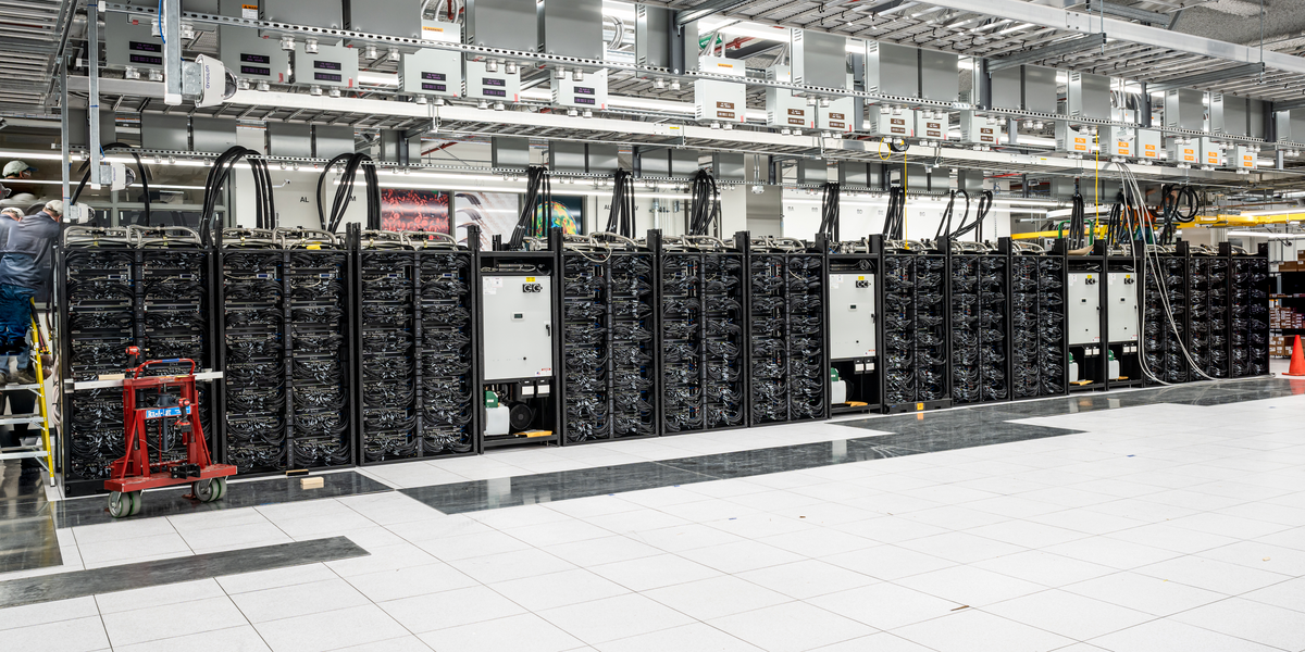 a-row-of-24-computer-racks-stand-on-one-side-of-a-large-room.png.5860cf9b67c4d0dfd5ac54969db7a4b2.png