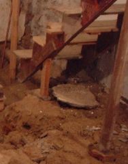 Decrepit basement steps on dirt floor